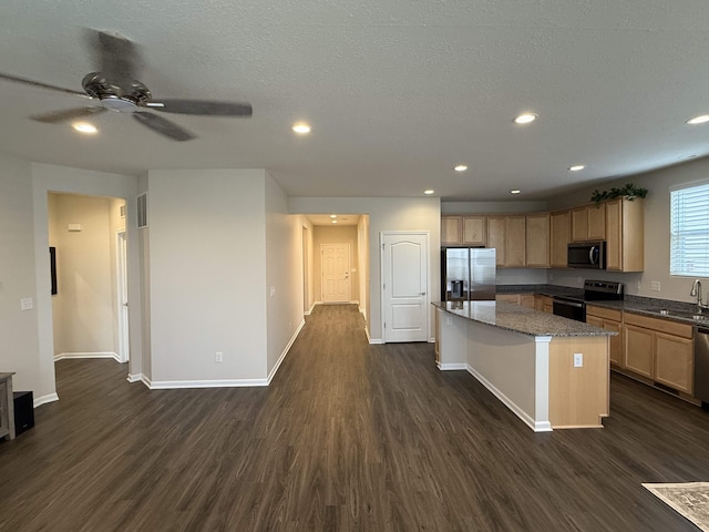 kitchen with stainless steel appliances, dark hardwood / wood-style floors, dark stone countertops, a textured ceiling, and a kitchen island