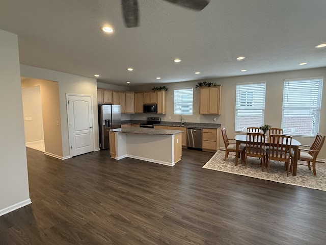 kitchen featuring appliances with stainless steel finishes, a center island, dark hardwood / wood-style flooring, and light brown cabinetry