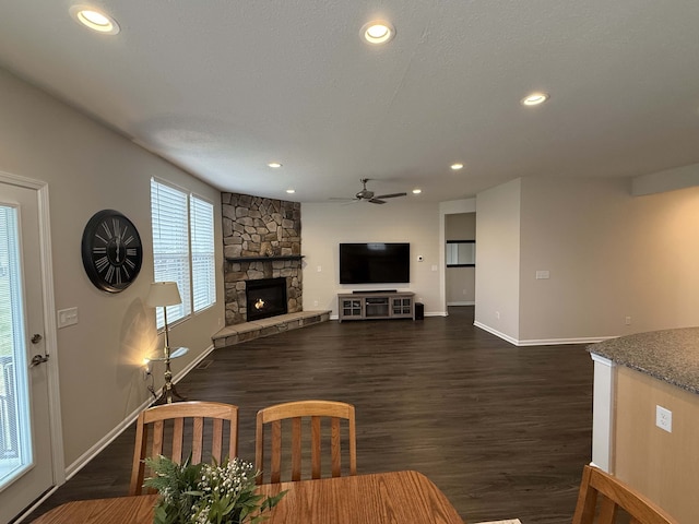 unfurnished living room with a fireplace, a textured ceiling, dark hardwood / wood-style flooring, and ceiling fan