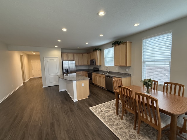 kitchen featuring sink, a center island, stainless steel appliances, light brown cabinets, and dark hardwood / wood-style floors