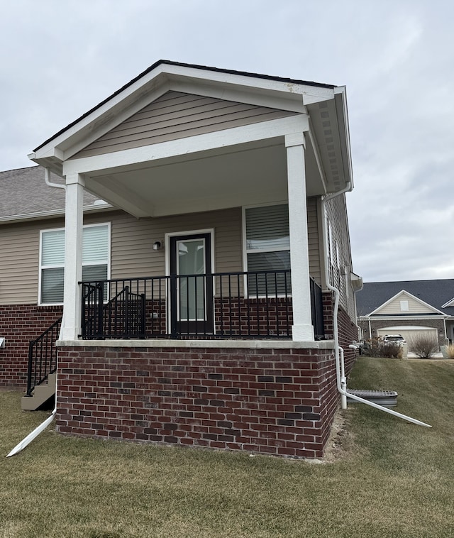 exterior space featuring covered porch and a front yard