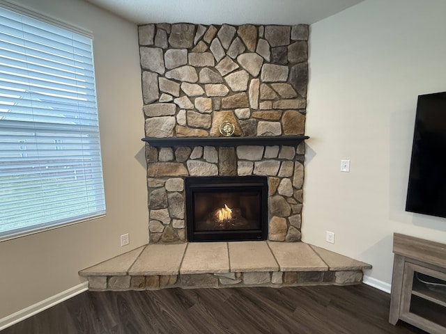 room details featuring hardwood / wood-style floors and a stone fireplace