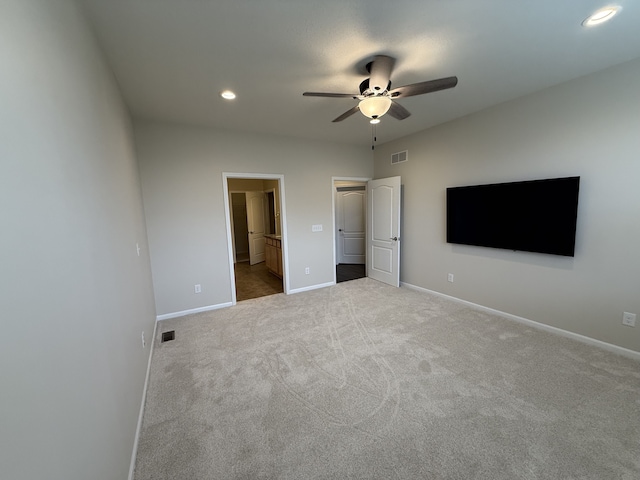 unfurnished bedroom with carpet flooring, ensuite bathroom, and ceiling fan