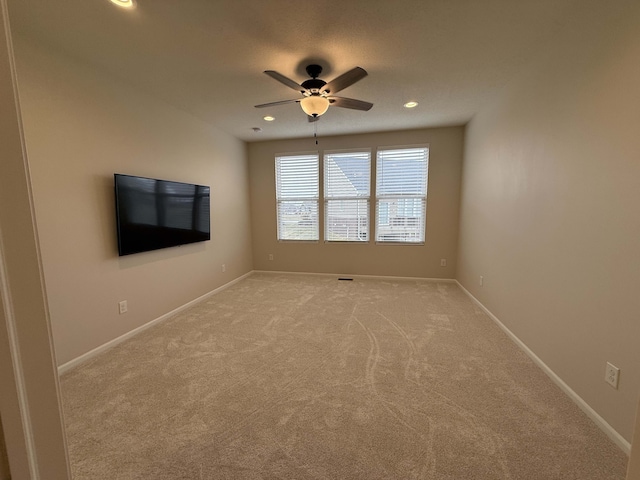 unfurnished room featuring ceiling fan and light colored carpet