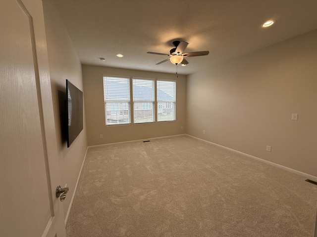 spare room featuring carpet and ceiling fan