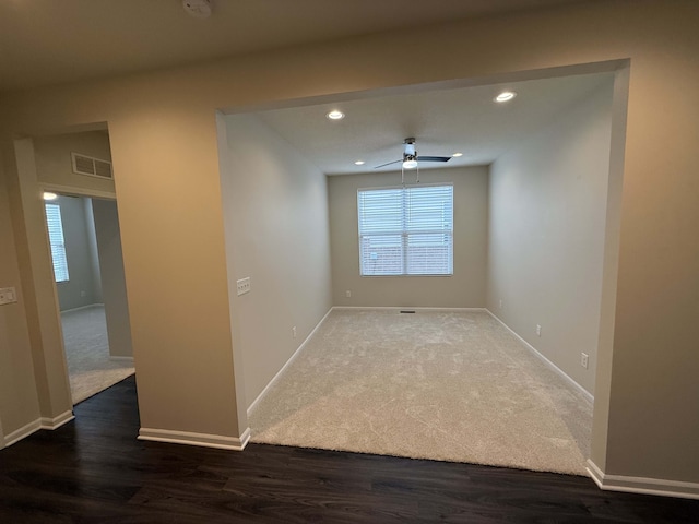 empty room with ceiling fan and dark wood-type flooring