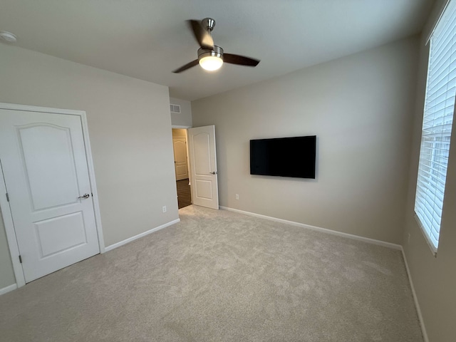 unfurnished bedroom featuring ceiling fan and light colored carpet