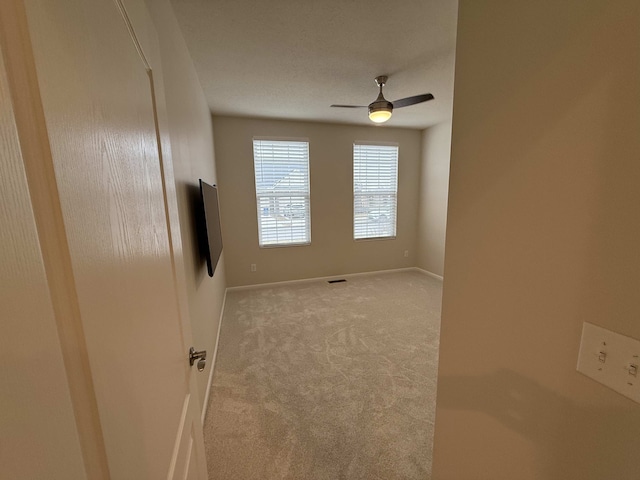 carpeted spare room with ceiling fan