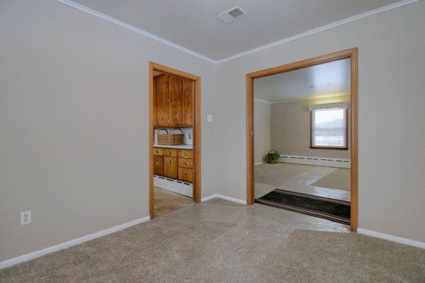 spare room with ornamental molding and a baseboard heating unit