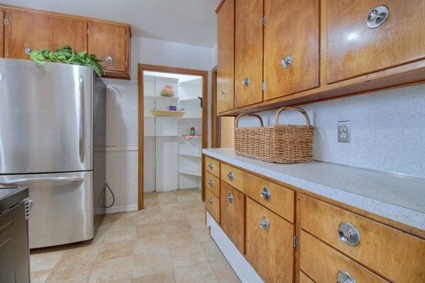 kitchen featuring stainless steel fridge and tasteful backsplash