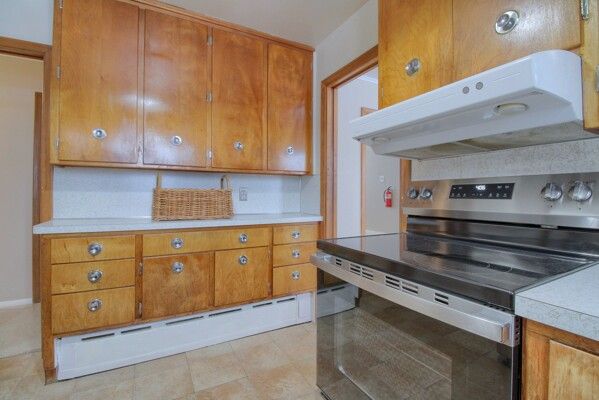 kitchen featuring a baseboard radiator and stainless steel range with electric stovetop