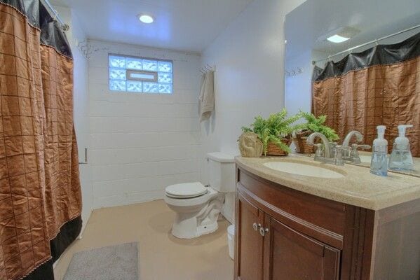 bathroom with a shower with shower curtain, vanity, and toilet