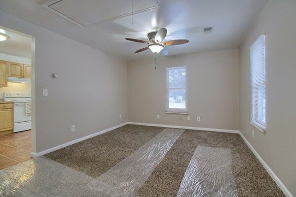 carpeted spare room with ceiling fan