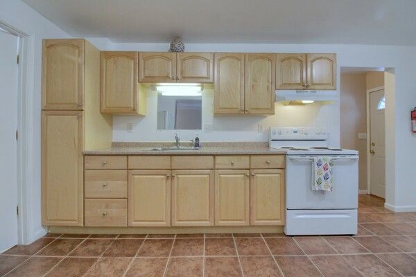 kitchen featuring sink, white electric range, and light brown cabinets