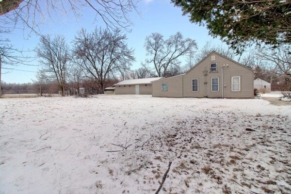 view of snow covered back of property