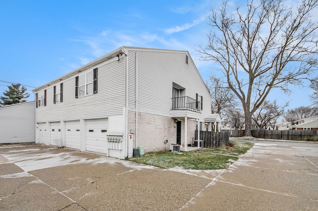 view of side of home featuring a balcony, a garage, and central AC unit