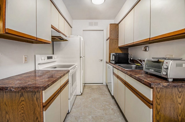 kitchen featuring white appliances, sink, and white cabinetry