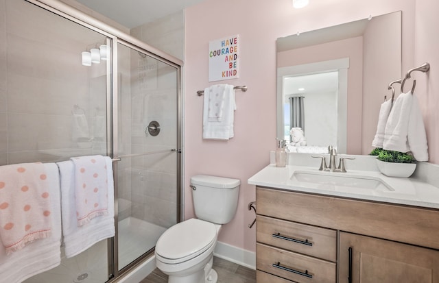 bathroom featuring vanity, toilet, and a shower with shower door