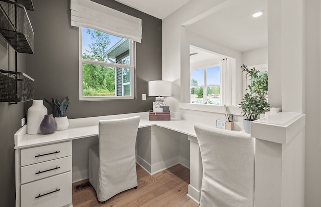 office area with built in desk and light hardwood / wood-style flooring