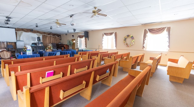 interior space with a paneled ceiling and ceiling fan