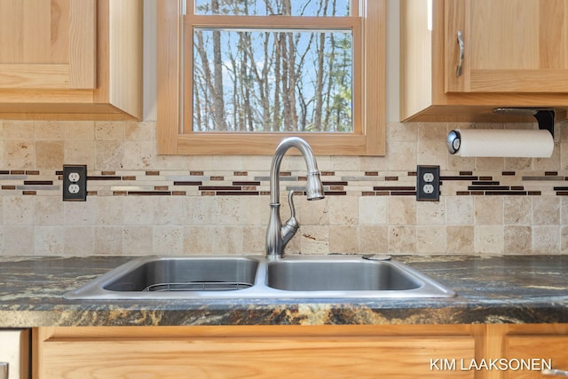 interior details featuring light brown cabinets, sink, and tasteful backsplash