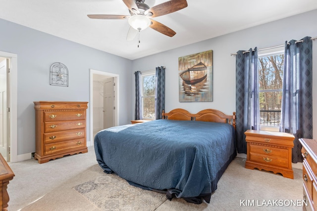 bedroom with light carpet, multiple windows, and ceiling fan