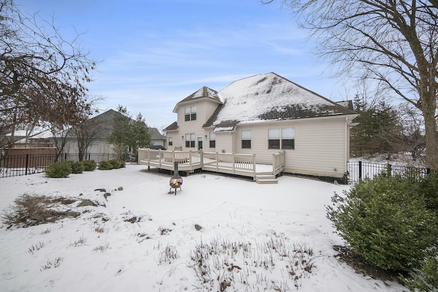 snow covered house with a wooden deck