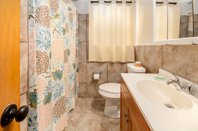 bathroom with toilet, tile walls, and vanity