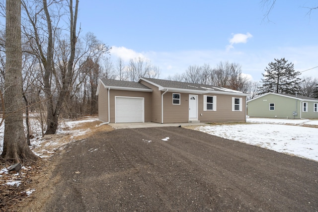 view of front facade with roof with shingles, an attached garage, and dirt driveway