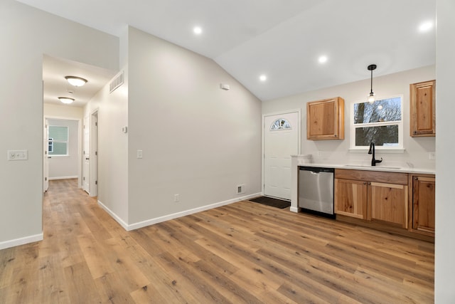 kitchen with dishwasher, lofted ceiling, sink, hanging light fixtures, and light wood-type flooring