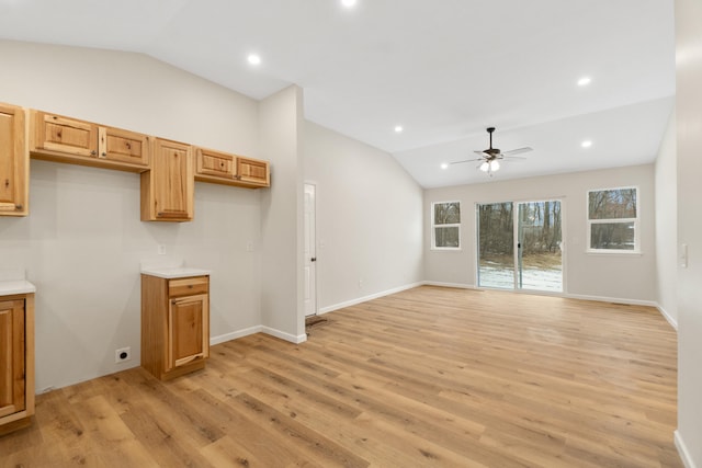 unfurnished living room with ceiling fan, vaulted ceiling, and light wood-type flooring