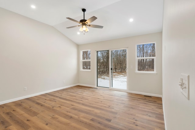 spare room with a ceiling fan, vaulted ceiling, baseboards, and wood finished floors