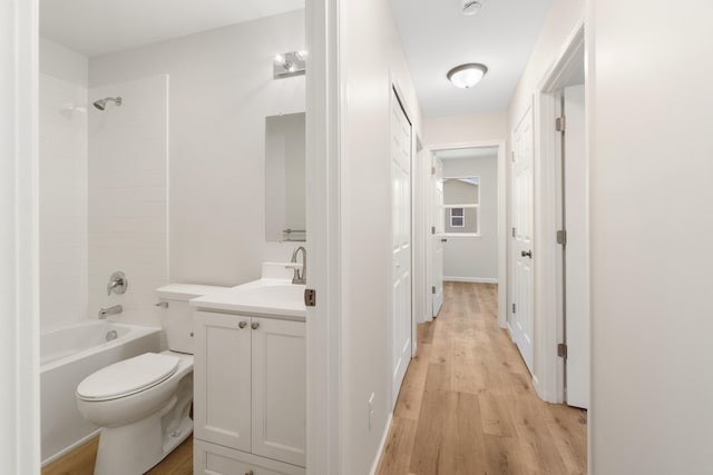 bathroom with toilet, shower / washtub combination, wood finished floors, and vanity