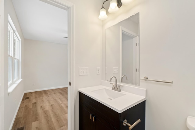 bathroom featuring wood finished floors, vanity, and baseboards