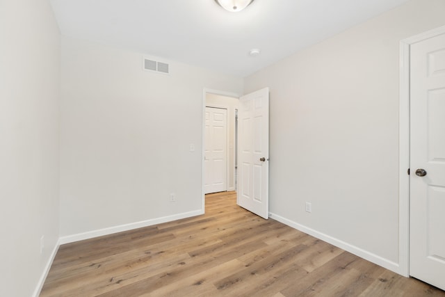 unfurnished bedroom featuring light wood-style flooring, visible vents, and baseboards