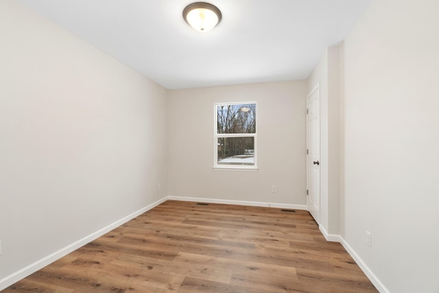 unfurnished room featuring baseboards and wood finished floors