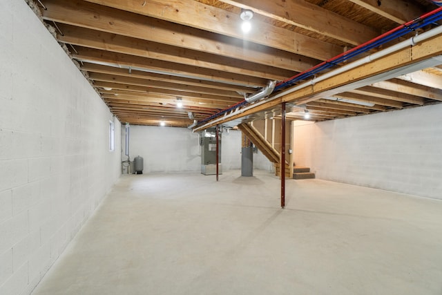 basement featuring electric water heater and heating unit