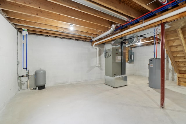 unfinished basement featuring electric panel, heating unit, and water heater