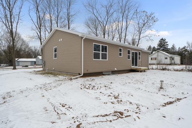 view of snow covered rear of property