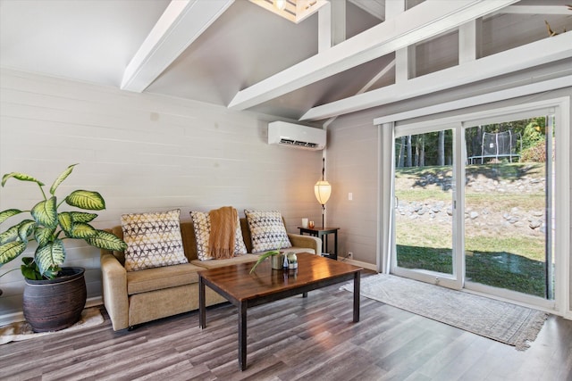 living room featuring vaulted ceiling with beams, an AC wall unit, and hardwood / wood-style flooring