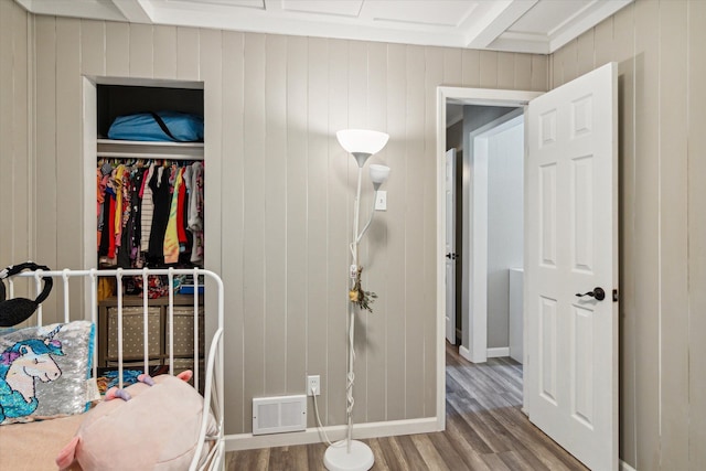 bedroom with hardwood / wood-style flooring and beamed ceiling