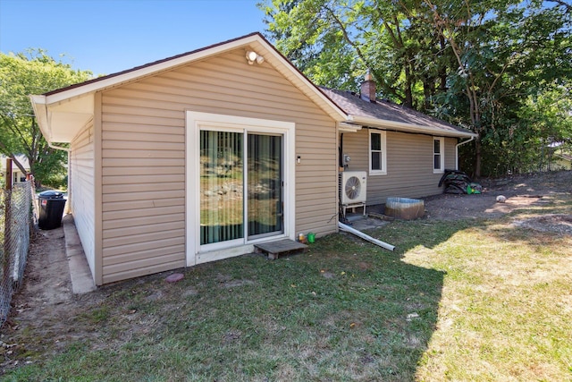 rear view of house featuring a lawn and ac unit