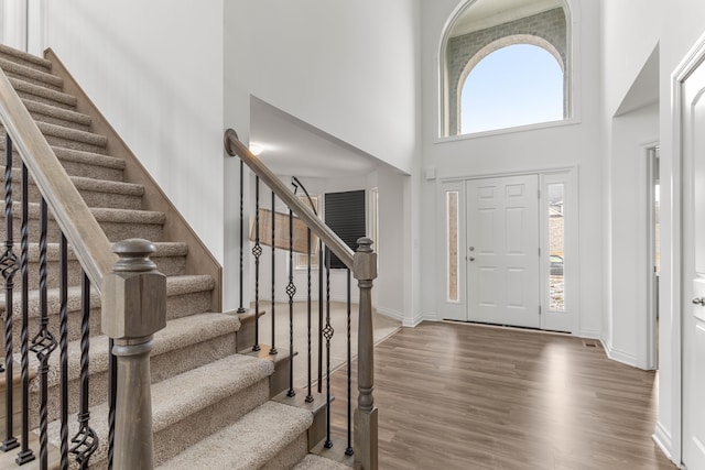 entryway with hardwood / wood-style floors and a high ceiling