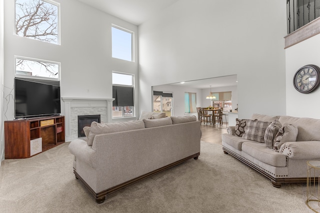 carpeted living room with a high ceiling and a chandelier