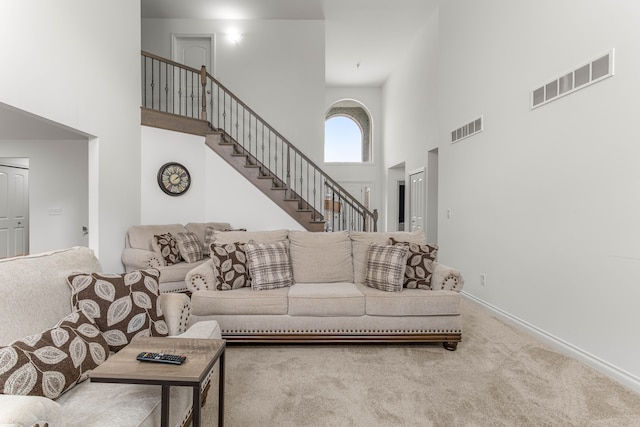 carpeted living room with a towering ceiling