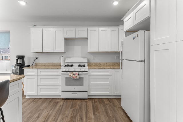 kitchen featuring white cabinets, white appliances, light stone countertops, and dark wood-type flooring