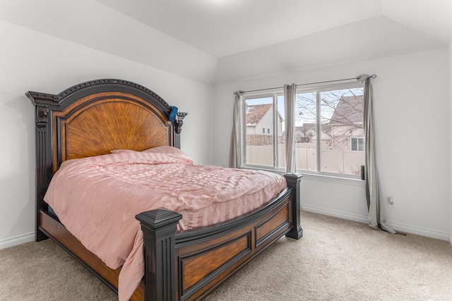 carpeted bedroom with a tray ceiling and multiple windows