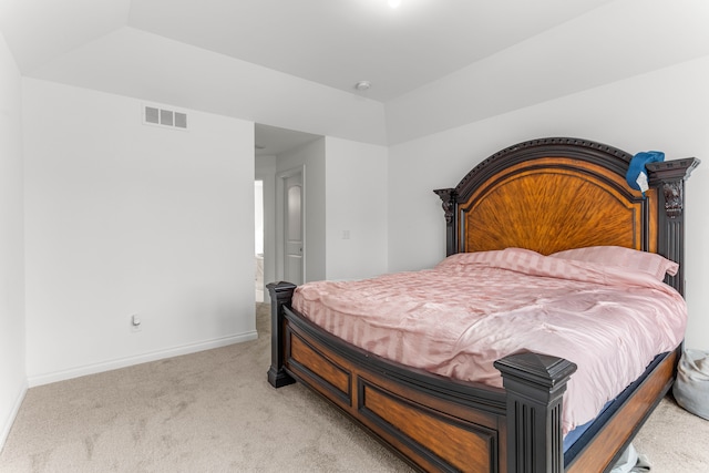 bedroom featuring a raised ceiling and light carpet