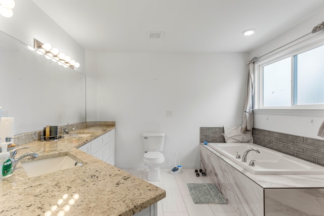 bathroom with tile patterned floors, tiled tub, vanity, and toilet