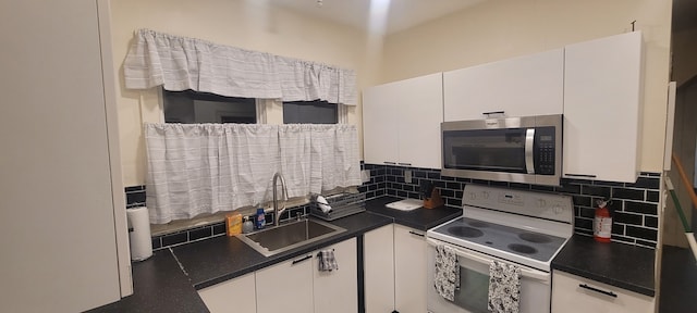 kitchen featuring white electric range, backsplash, white cabinetry, and sink